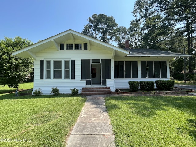148 N Mitchell Ford Rd, Clarkton, NC 28433 - view of front of house with a sunroom, a front lawn, a chimney, and entry steps