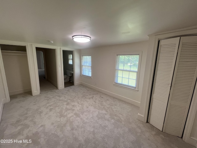 148 N Mitchell Ford Rd, Clarkton, NC 28433 - unfurnished bedroom with multiple closets, light carpet, and ensuite bath