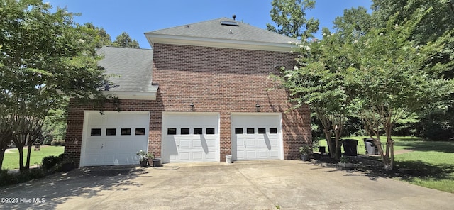 3129 Lake Pointe Trl, Rocky Mount, NC 27804 - view of side of home featuring a shingled roof, concrete driveway, a garage, brick siding, and a lawn