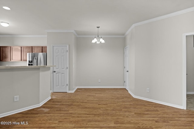 231 Glenhaven Ln, Jacksonville, NC 28546 - kitchen featuring stainless steel fridge, a chandelier, wood finished floors, crown molding, and light countertops