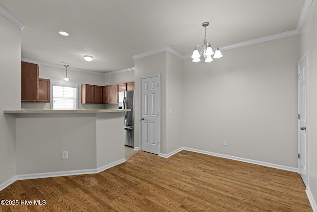 231 Glenhaven Ln, Jacksonville, NC 28546 - kitchen with freestanding refrigerator, ornamental molding, light wood finished floors, a chandelier, and decorative light fixtures