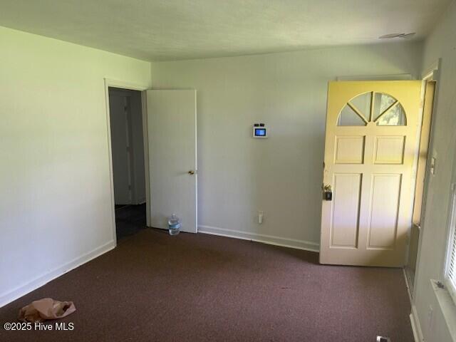 513 Hall Siding Rd, Ahoskie, NC 27910 - unfurnished bedroom with dark colored carpet and baseboards