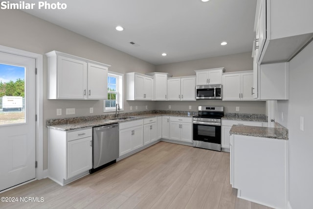 770 Aria Ln, Hubert, NC 28539 - kitchen with stainless steel appliances, light stone countertops, light wood finished floors, white cabinetry, and recessed lighting