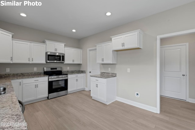 770 Aria Ln, Hubert, NC 28539 - kitchen featuring appliances with stainless steel finishes, light wood-type flooring, light stone counters, white cabinets, and recessed lighting