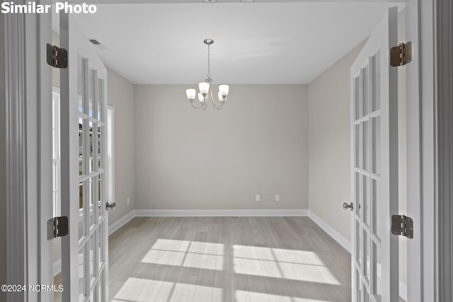 770 Aria Ln, Hubert, NC 28539 - empty room with french doors, wood finished floors, and a chandelier