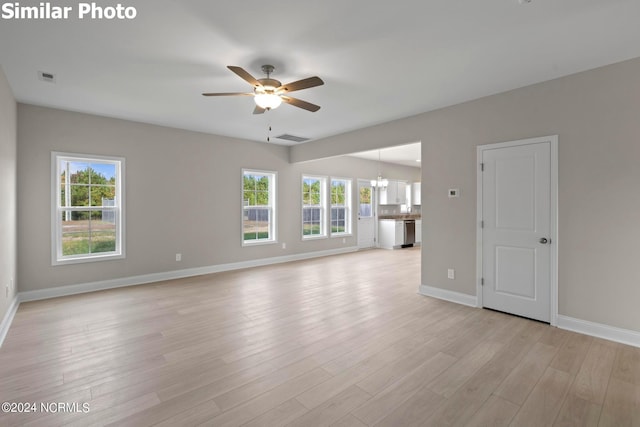 770 Aria Ln, Hubert, NC 28539 - unfurnished living room featuring a ceiling fan, light wood-style flooring, and a chandelier