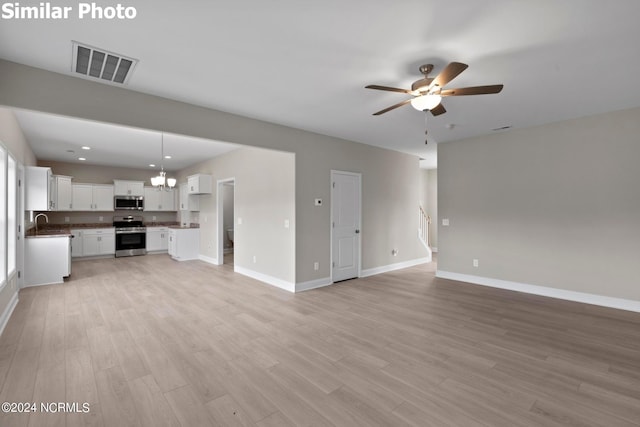 770 Aria Ln, Hubert, NC 28539 - unfurnished living room featuring a ceiling fan, light wood-type flooring, recessed lighting, and a chandelier