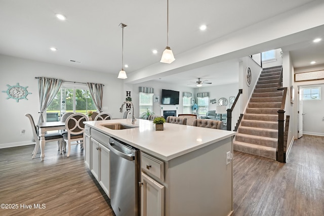 129 Glenmoor Path, Moyock, NC 27958 - kitchen with stainless steel dishwasher, dark wood finished floors, a fireplace, decorative light fixtures, and recessed lighting