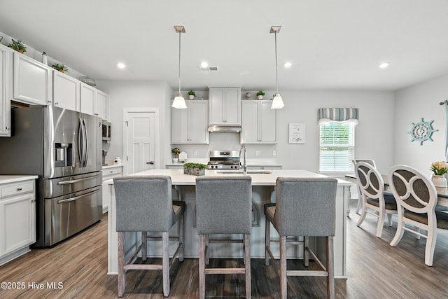 129 Glenmoor Path, Moyock, NC 27958 - kitchen with appliances with stainless steel finishes, a center island with sink, light countertops, dark wood-style flooring, and recessed lighting