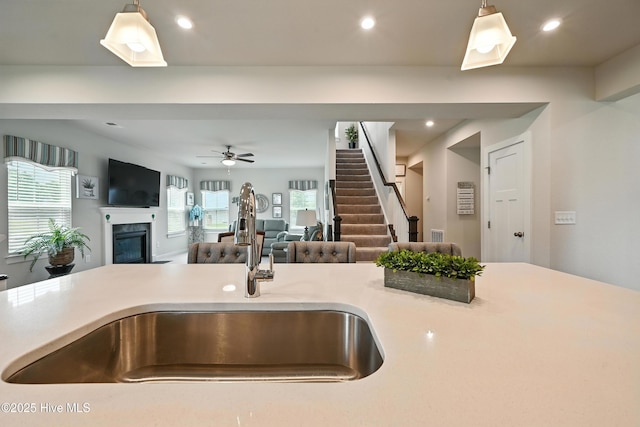 129 Glenmoor Path, Moyock, NC 27958 - kitchen featuring open floor plan, hanging light fixtures, a glass covered fireplace, light countertops, and a ceiling fan