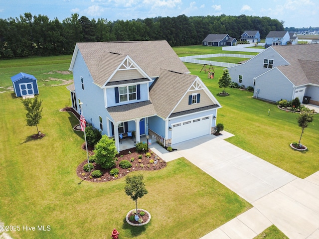 129 Glenmoor Path, Moyock, NC 27958 - view of front of property featuring a porch, concrete driveway, a garage, stone siding, and a shingled roof