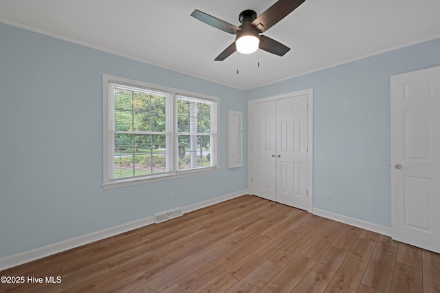 2704 Forrest Dr, Kinston, NC 28504 - unfurnished bedroom with wood finished floors, crown molding, a closet, and a ceiling fan