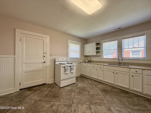 603 E 8th St, Washington, NC 27889 - kitchen featuring white range with electric stovetop, white cabinets, open shelves, a wainscoted wall, and light countertops