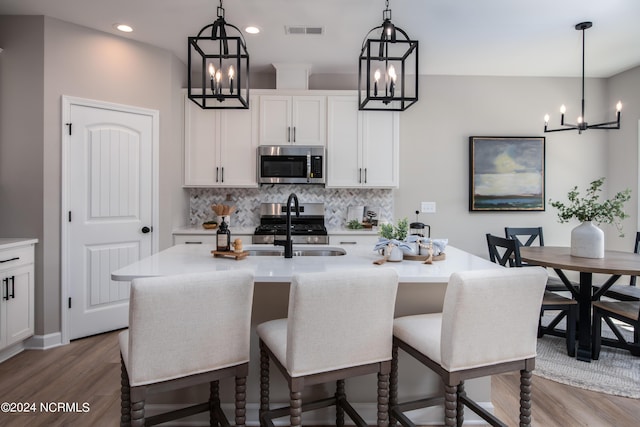 301 Glassmine Trl Unit 48, Aberdeen, NC 28315 - kitchen featuring stainless steel appliances, a chandelier, wood finished floors, tasteful backsplash, and recessed lighting