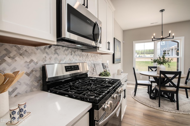 301 Glassmine Trl Unit 48, Aberdeen, NC 28315 - kitchen featuring stainless steel appliances, a chandelier, light wood finished floors, white cabinetry, and light countertops