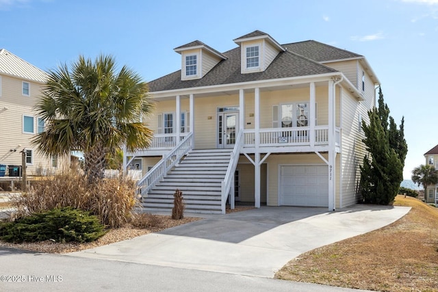 9711 Dolphin Ridge Rd, Emerald Isle, NC 28594 - coastal inspired home with covered porch, a garage, stairway, concrete driveway, and a shingled roof