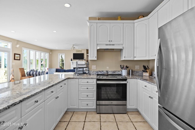 9711 Dolphin Ridge Rd, Emerald Isle, NC 28594 - kitchen featuring appliances with stainless steel finishes, under cabinet range hood, white cabinetry, light stone countertops, and recessed lighting