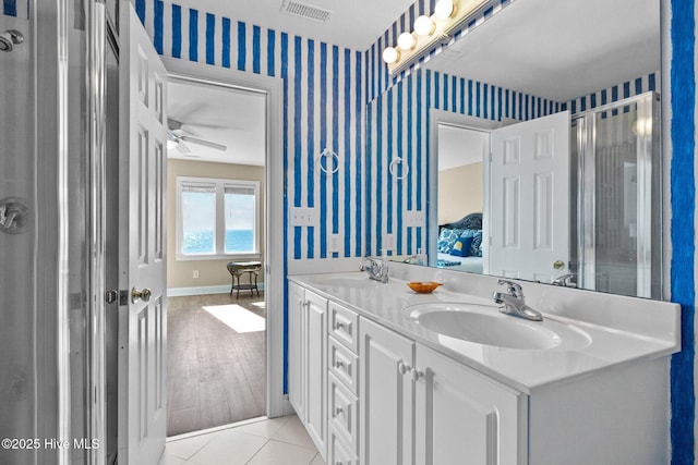 9711 Dolphin Ridge Rd, Emerald Isle, NC 28594 - bathroom with wallpapered walls, double vanity, a ceiling fan, connected bathroom, and tile patterned floors