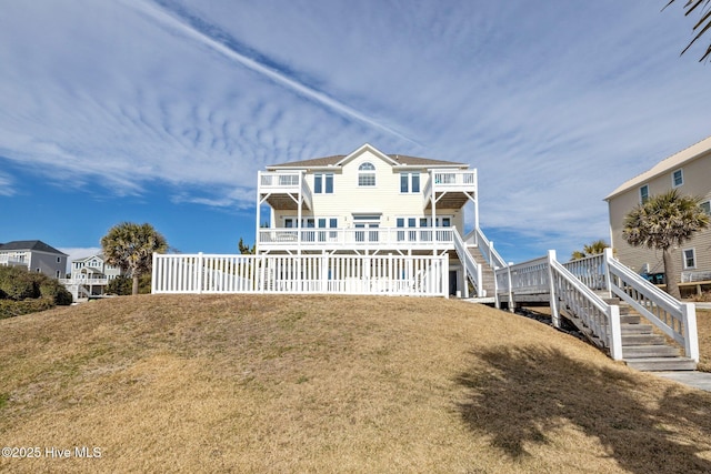 9711 Dolphin Ridge Rd, Emerald Isle, NC 28594 - rear view of house featuring stairs, a balcony, and a lawn