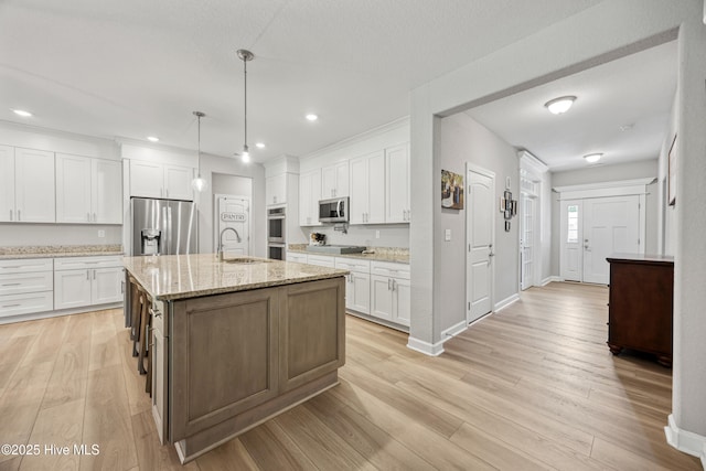 145 Beechnut Ave, South Mills, NC 27976 - kitchen featuring appliances with stainless steel finishes, white cabinetry, light wood-style floors, a kitchen island with sink, and recessed lighting