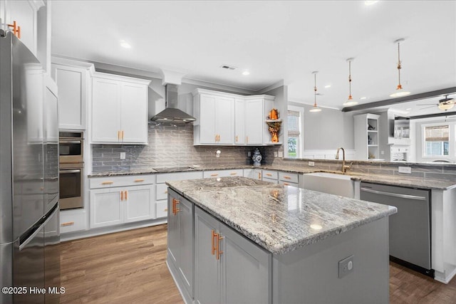 385 Summerhouse Dr, Holly Ridge, NC 28445 - kitchen with stainless steel appliances, wall chimney exhaust hood, a peninsula, healthy amount of natural light, and ornamental molding
