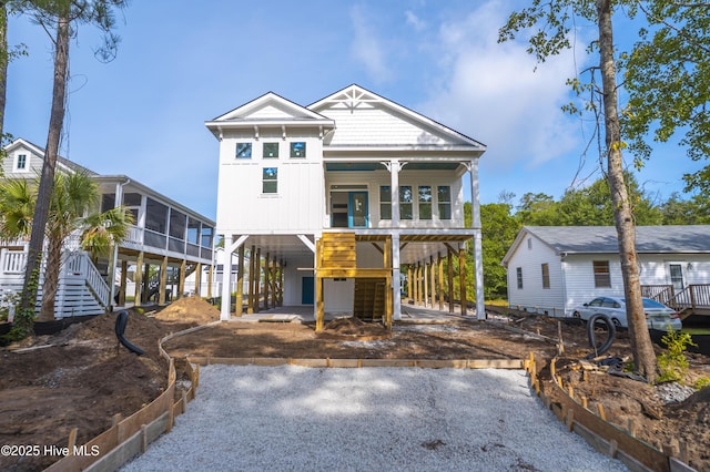 337 NE 48th St, Oak Island, NC 28465 - coastal inspired home with stairway, a carport, a porch, and driveway