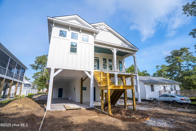 337 NE 48th St, Oak Island, NC 28465 - back of house with board and batten siding, a carport, and stairway