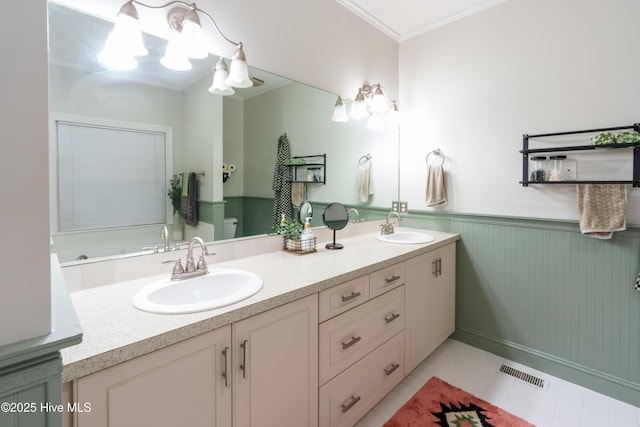 4409 Pinehurst Dr N, Wilson, NC 27896 - bathroom featuring double vanity, wainscoting, tile patterned floors, and crown molding
