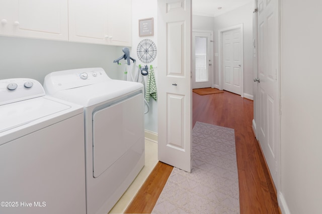 4409 Pinehurst Dr N, Wilson, NC 27896 - laundry room with washing machine and clothes dryer, light wood-style floors, cabinet space, and ornamental molding