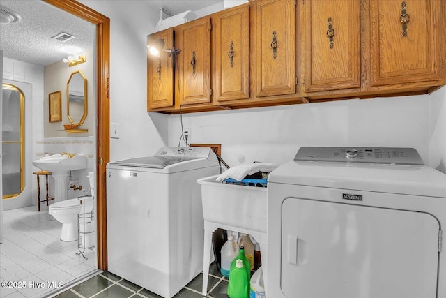 198 Verona Rd, Jacksonville, NC 28540 - laundry room with cabinet space, independent washer and dryer, a textured ceiling, and tile patterned flooring