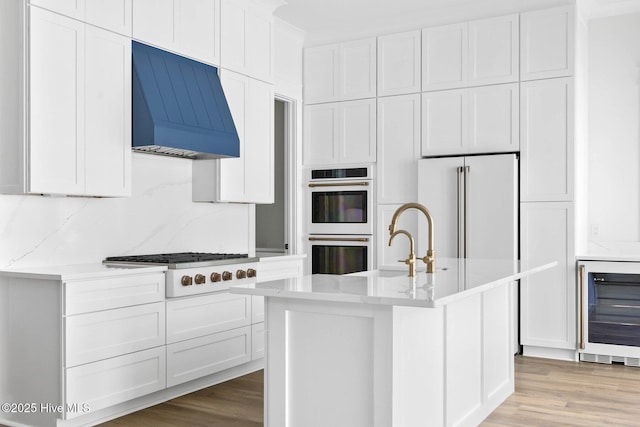 1320 Searay Ln, Carolina Beach, NC 28428 - kitchen featuring custom exhaust hood, double oven, wine cooler, gas stovetop, and white cabinets