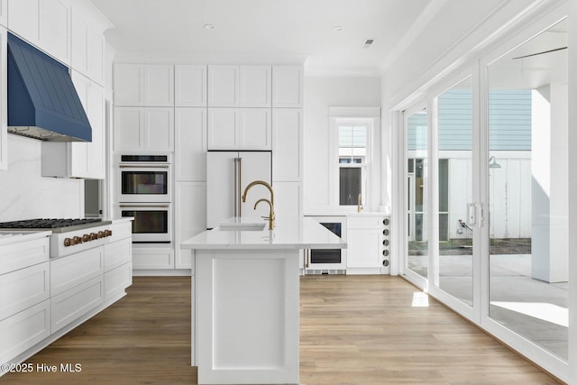 1320 Searay Ln, Carolina Beach, NC 28428 - kitchen with double oven, extractor fan, stainless steel gas stovetop, high quality fridge, and beverage cooler