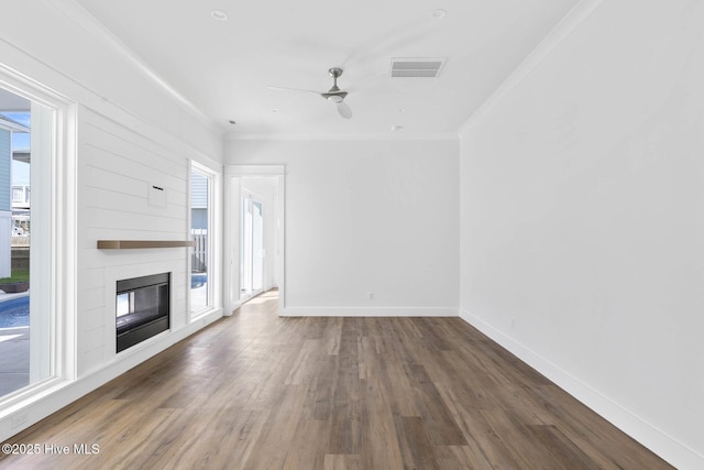 1320 Searay Ln, Carolina Beach, NC 28428 - unfurnished living room featuring plenty of natural light, wood finished floors, crown molding, and a fireplace