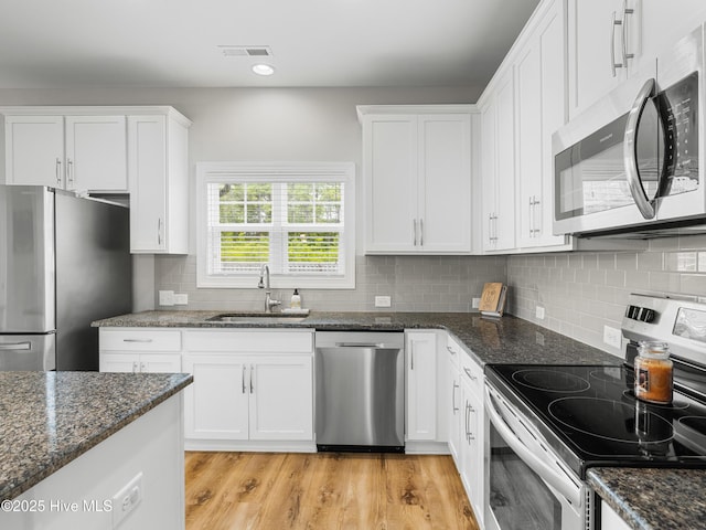 510 Transom Way, Sneads Ferry, NC 28460 - kitchen with stainless steel appliances, white cabinetry, dark stone counters, tasteful backsplash, and recessed lighting
