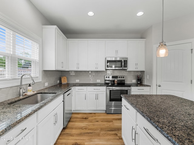 510 Transom Way, Sneads Ferry, NC 28460 - kitchen featuring stainless steel appliances, white cabinetry, decorative backsplash, hanging light fixtures, and dark stone counters