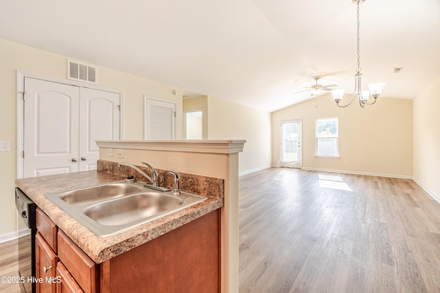 3021 Evening Rd, Castle Hayne, NC 28429 - kitchen with brown cabinets, light wood finished floors, an island with sink, a chandelier, and lofted ceiling