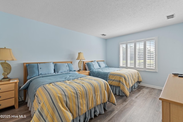811 Colony Pl # D, Sunset Beach, NC 28468 - bedroom with wood finished floors and a textured ceiling
