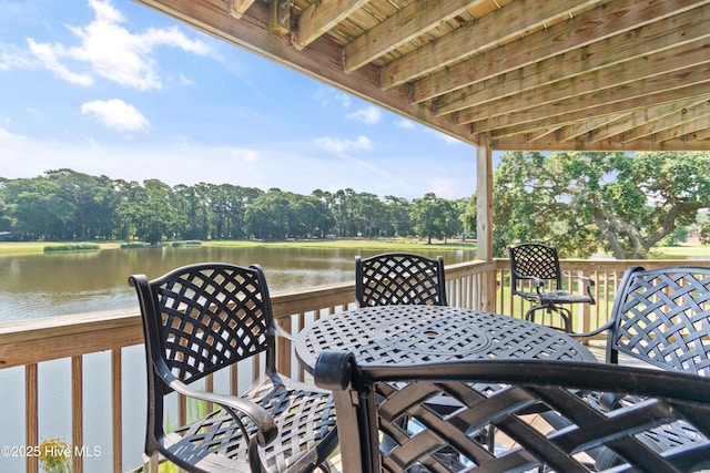811 Colony Pl # D, Sunset Beach, NC 28468 - wooden terrace featuring a water view, outdoor dining area, and view of scattered trees