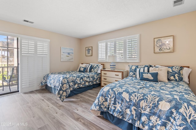 811 Colony Pl # D, Sunset Beach, NC 28468 - bedroom featuring multiple windows, wood finished floors, and access to outside