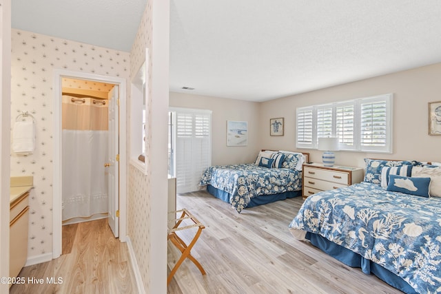 811 Colony Pl # D, Sunset Beach, NC 28468 - bedroom featuring light wood finished floors, multiple windows, and wallpapered walls