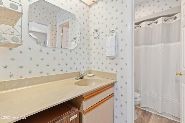 811 Colony Pl # D, Sunset Beach, NC 28468 - bathroom with wallpapered walls, vanity, wood finished floors, and curtained shower