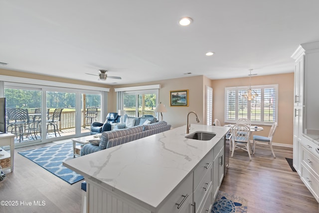 811 Colony Pl # D, Sunset Beach, NC 28468 - kitchen with plenty of natural light, wood finished floors, a chandelier, white cabinets, and recessed lighting
