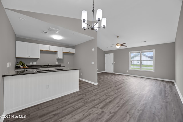 6739 Newbury Way, Wilmington, NC 28411 - kitchen with dark countertops, lofted ceiling, a ceiling fan, dark wood-style floors, and white cabinets