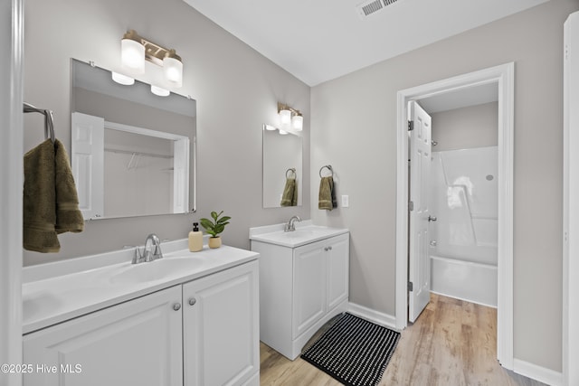 6739 Newbury Way, Wilmington, NC 28411 - full bath featuring two vanities, wood finished floors, and  shower combination