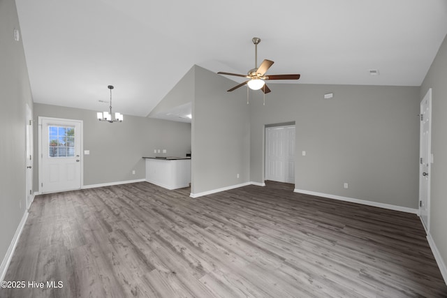 6739 Newbury Way, Wilmington, NC 28411 - unfurnished living room featuring lofted ceiling, a ceiling fan, a chandelier, and wood finished floors