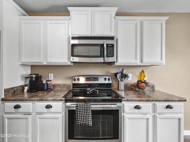 206 Riverstone Ct, Jacksonville, NC 28546 - kitchen featuring stainless steel appliances, dark countertops, white cabinets, and a textured ceiling