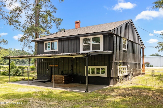 1955 Banks School Rd, Kinston, NC 28504 - rear view of house with board and batten siding, roof with shingles, a chimney, and a patio