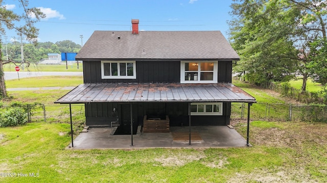 1955 Banks School Rd, Kinston, NC 28504 - rear view of property featuring a patio, a fenced backyard, a chimney, board and batten siding, and roof with shingles