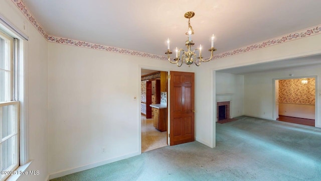 707 S Claiborne St, Goldsboro, NC 27530 - empty room featuring a chandelier, light colored carpet, and a fireplace