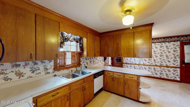 707 S Claiborne St, Goldsboro, NC 27530 - kitchen with white dishwasher, wallpapered walls, light countertops, brown cabinetry, and light flooring